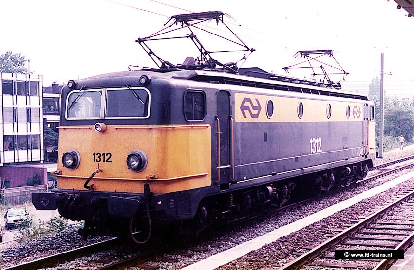 Electric locomotive. About two thirds blue, one third yellow.. The number 1312 is on the front and side. Electric locomotive. About two thirds blue, one third yellow.. The number 1312 is on the front and side.