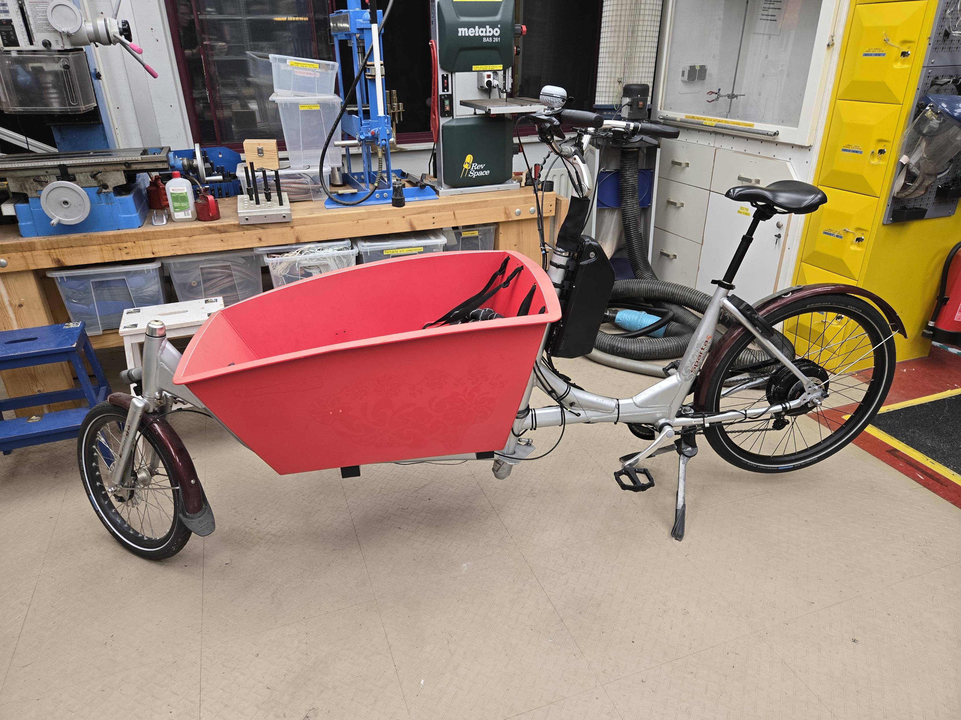 Finished electric cargo bike with a big red plastic cargo box